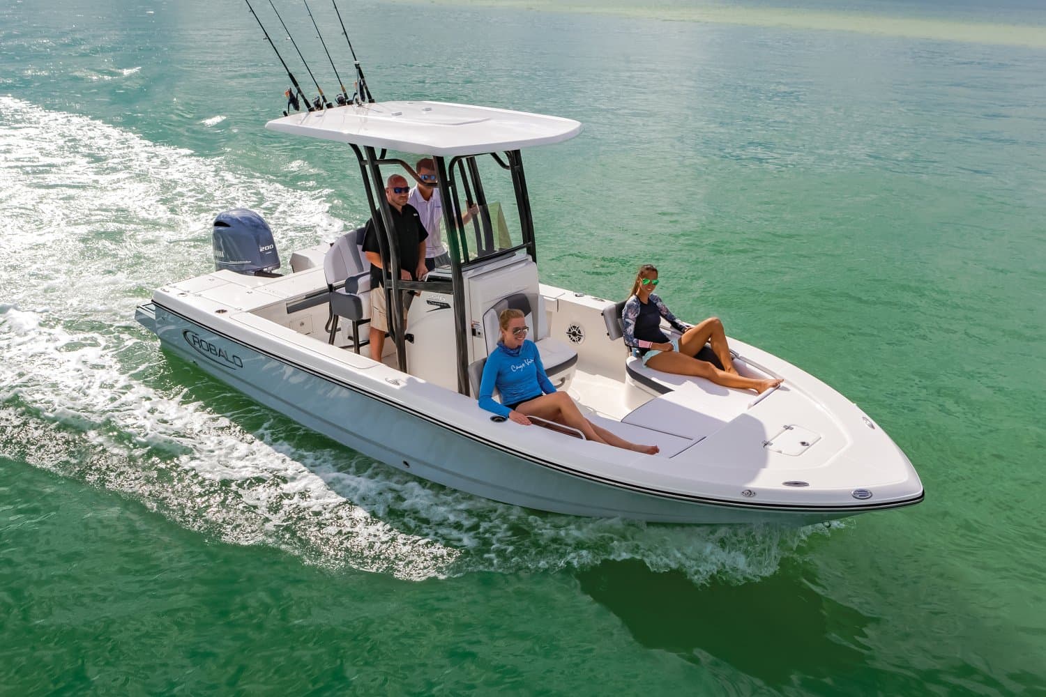 Robalo 226 Cayman cruising over clear green shallows with four people aboard, seen from above off the starboard side.