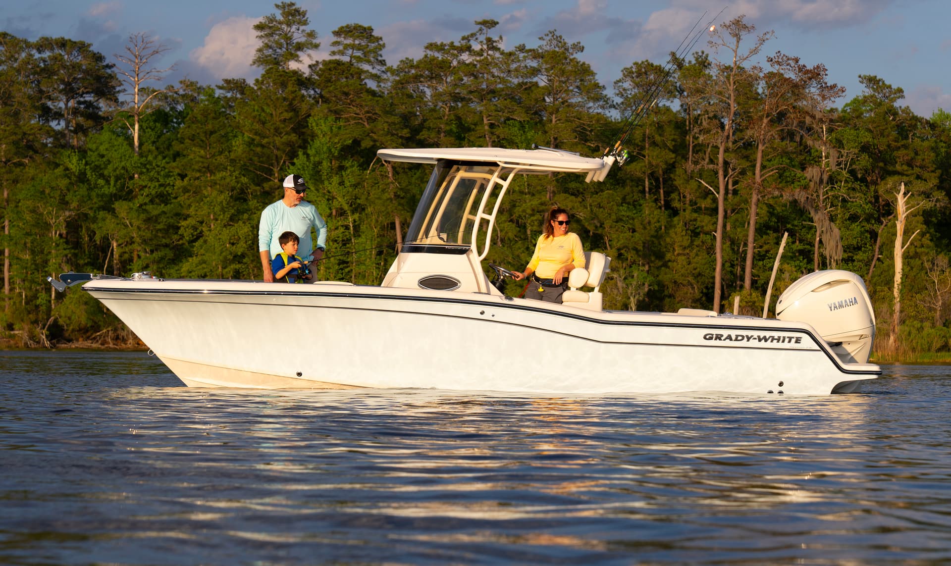 A family fishing from a Grady-White Fisherman 236 center console on calm inshore water